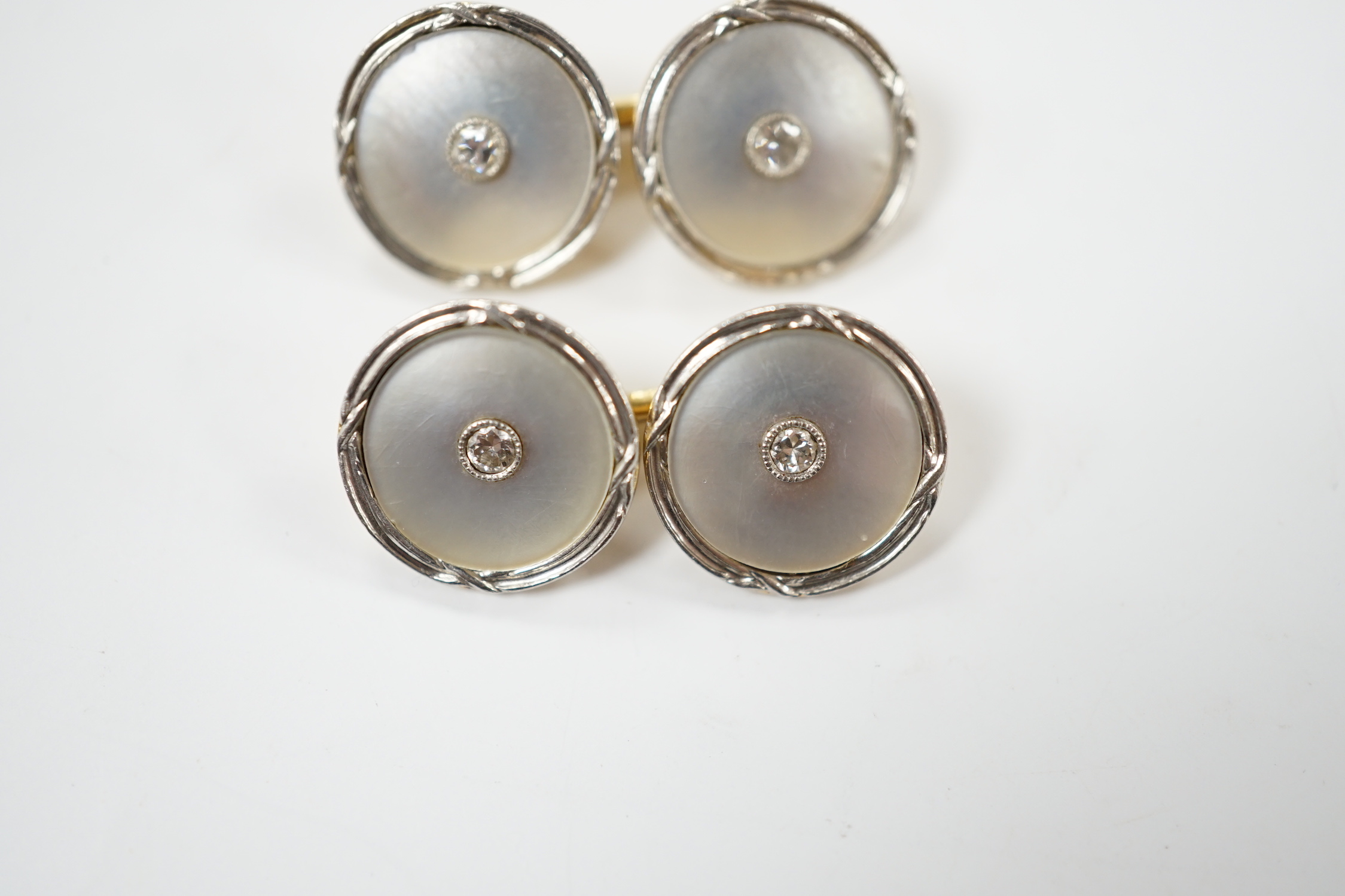 A pair of 14k yellow metal, mother of pearl and diamond chip set circular cufflinks, 12mm, gross weight 6.4 grams.